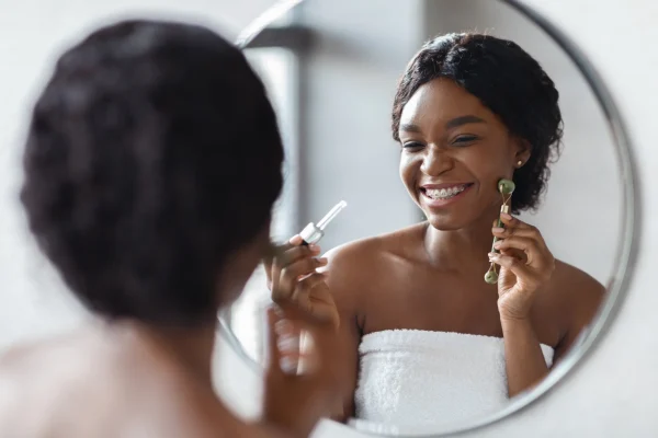 beautiful-african-american-woman-using-facial-roll-2022-12-16-07-05-53-utc